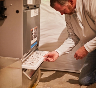 man replacing a furnace filter